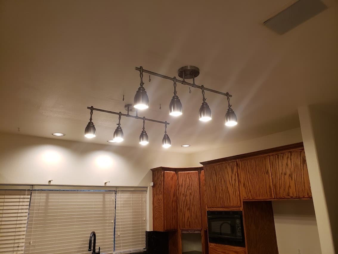 Decorative pendant light fixtures hung over a kitchen island after installation