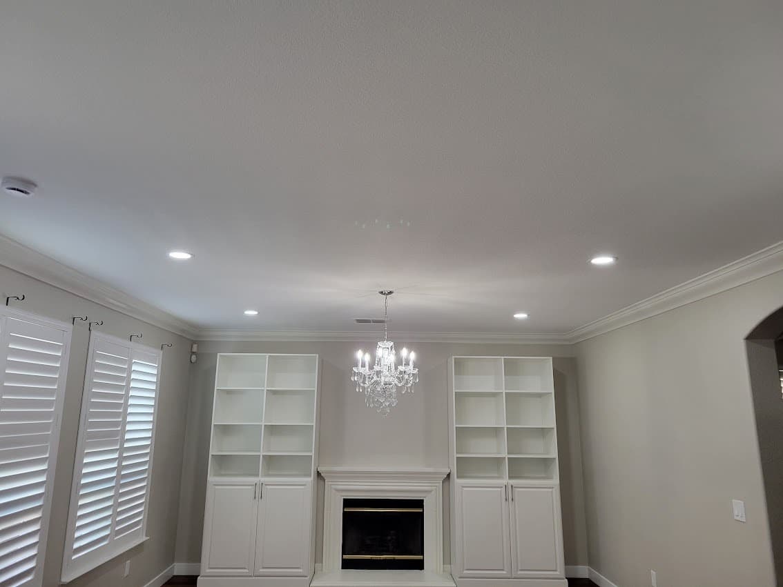 Finished recessed can lighting installed in a ceiling, evenly spaced and trimmed out