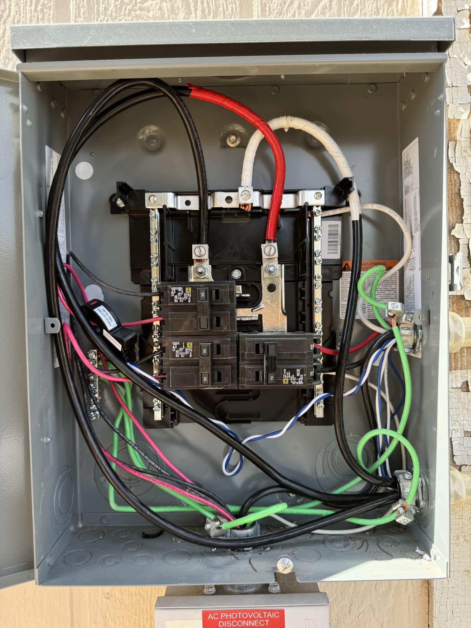 Interior of a completed 200A service panel with breakers installed and branch-circuit conductors dressed into neat runs